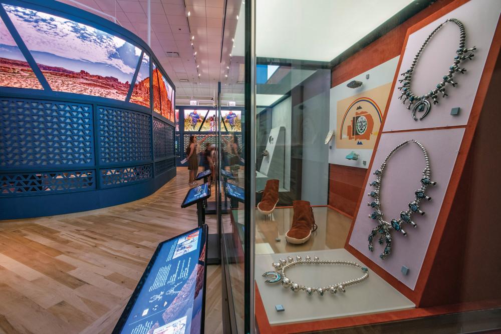 A display case at the Native Truths exhibit showing necklaces, footwear, and other items.